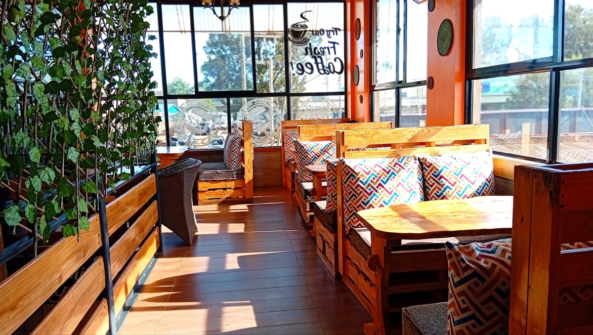 Cozy wooden seating area by window - King'ong'o Branch